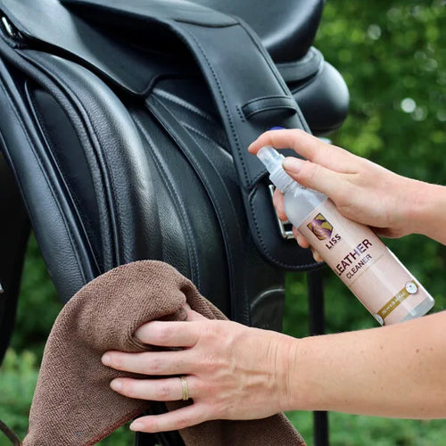 LISS Leather Care spray being applied to a leather saddle for a water-repellent finish